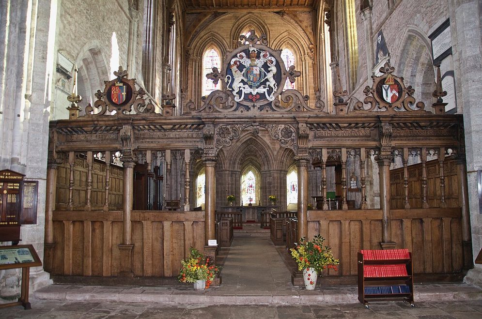The carved oak screen of the 1630s at Dore Abbey, topped by the royal arms, with the presbytery seen through its opening