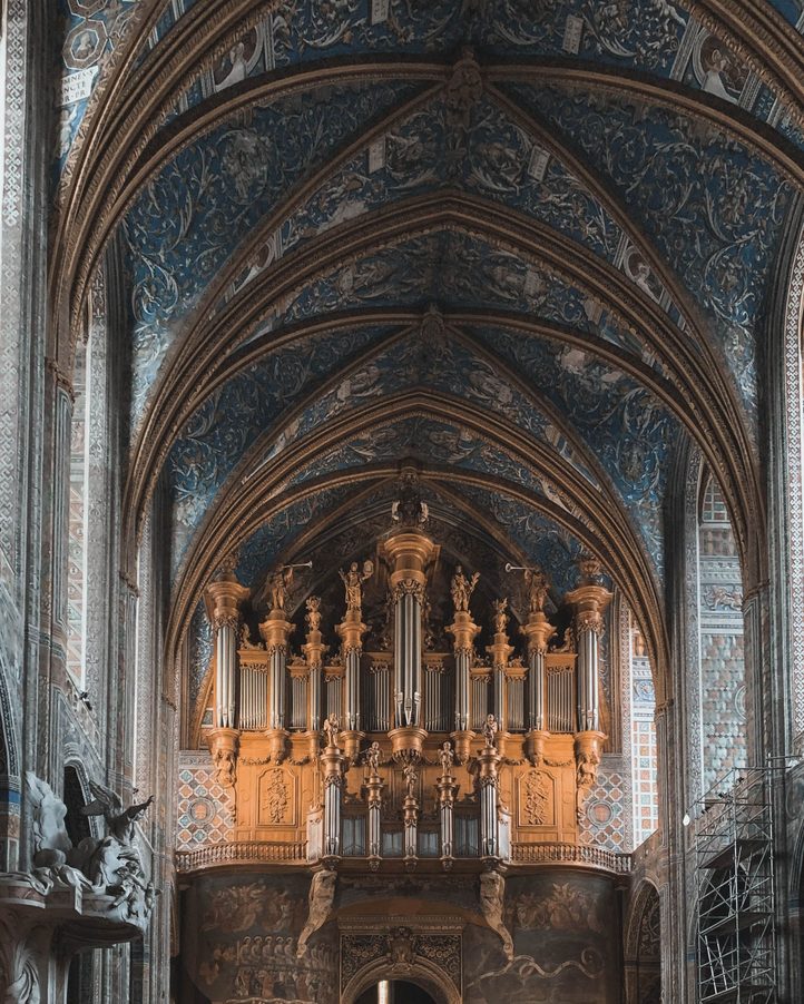 The great organ of Albi Cathedral filling the west end of the nave beneath the painted blue and gold vault