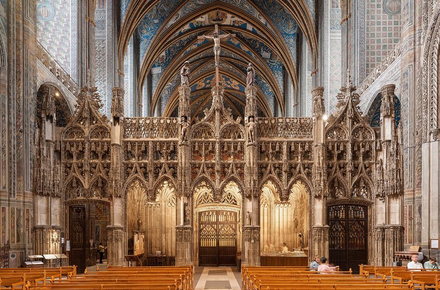 The lacy white stone rood screen of Albi Cathedral, with Flamboyant Gothic pinnacles and statues, closing off the choir