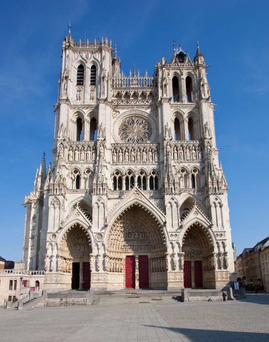 The west front of Amiens Cathedral, with three deep sculpted portals, a rose window and two unequal towers