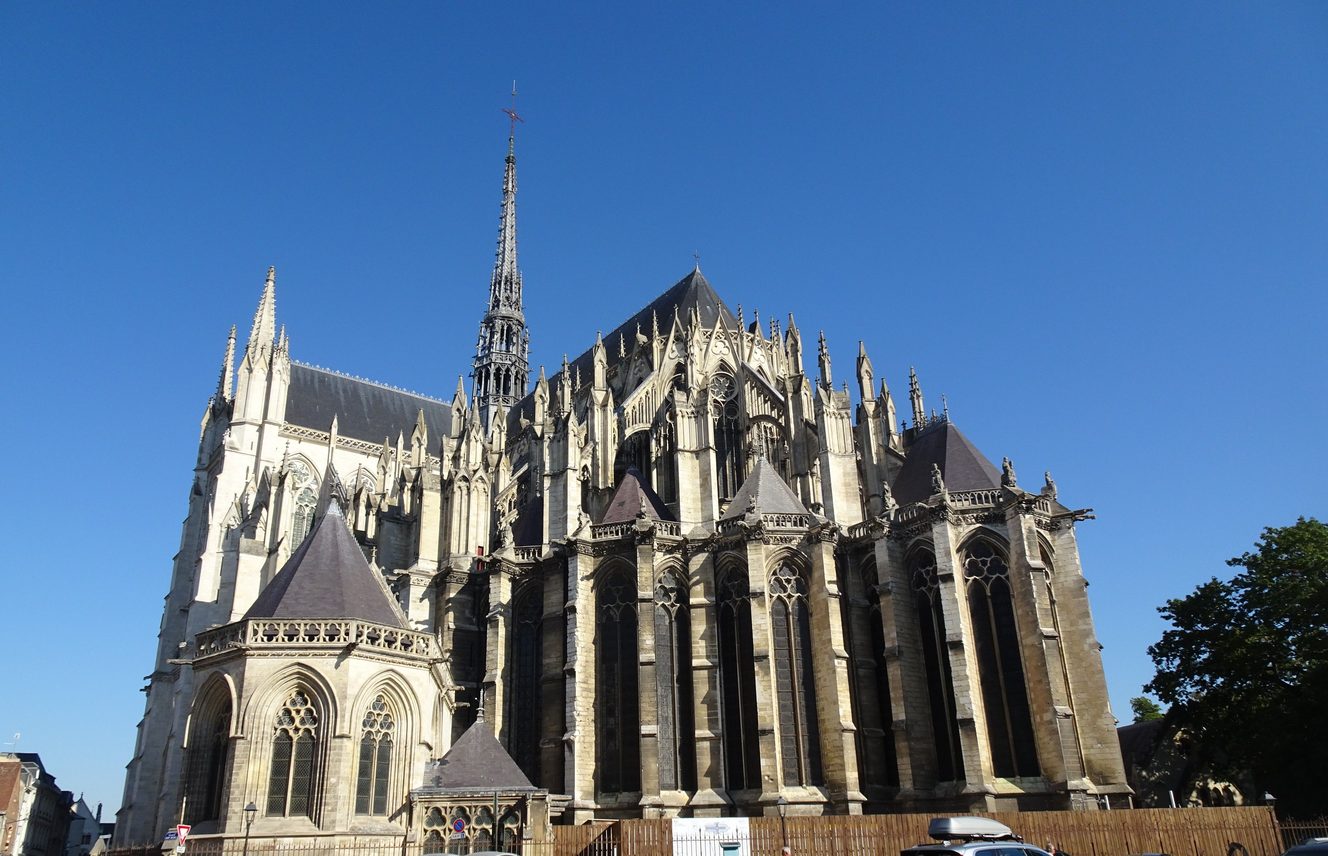 Amiens Cathedral from the south-east, with its flying buttresses, chapels and slender spire under a blue sky