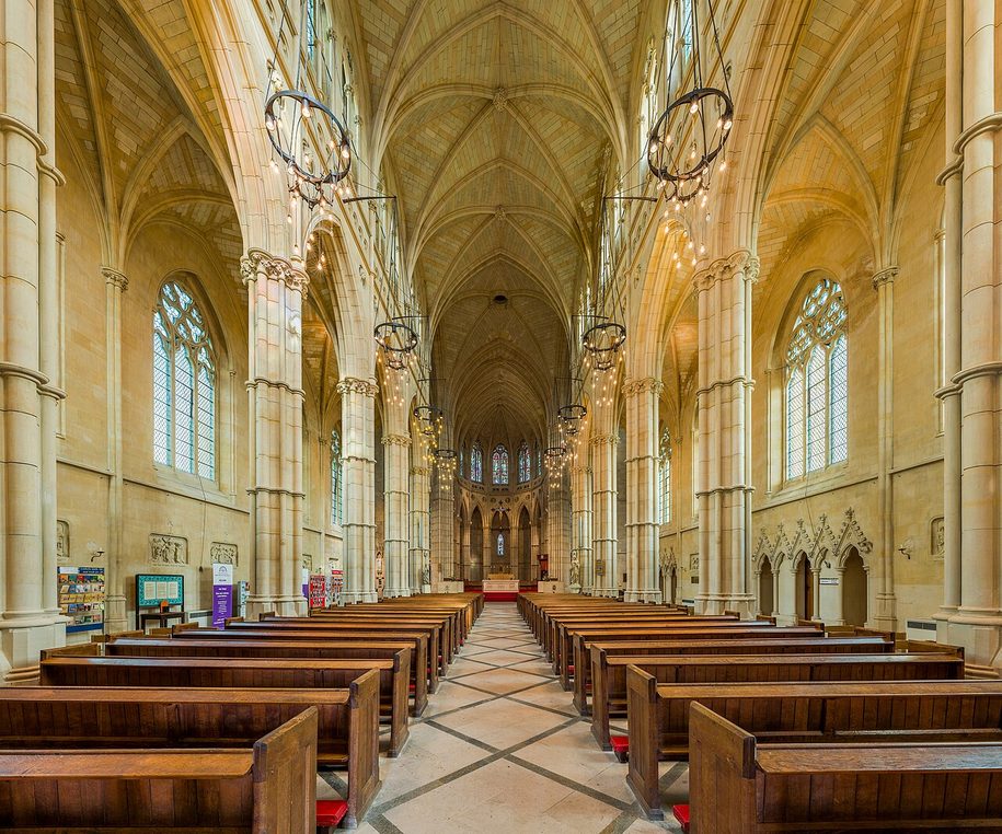 The tall, narrow nave of Arundel Cathedral, with slender columns and pointed arches leading to the apse