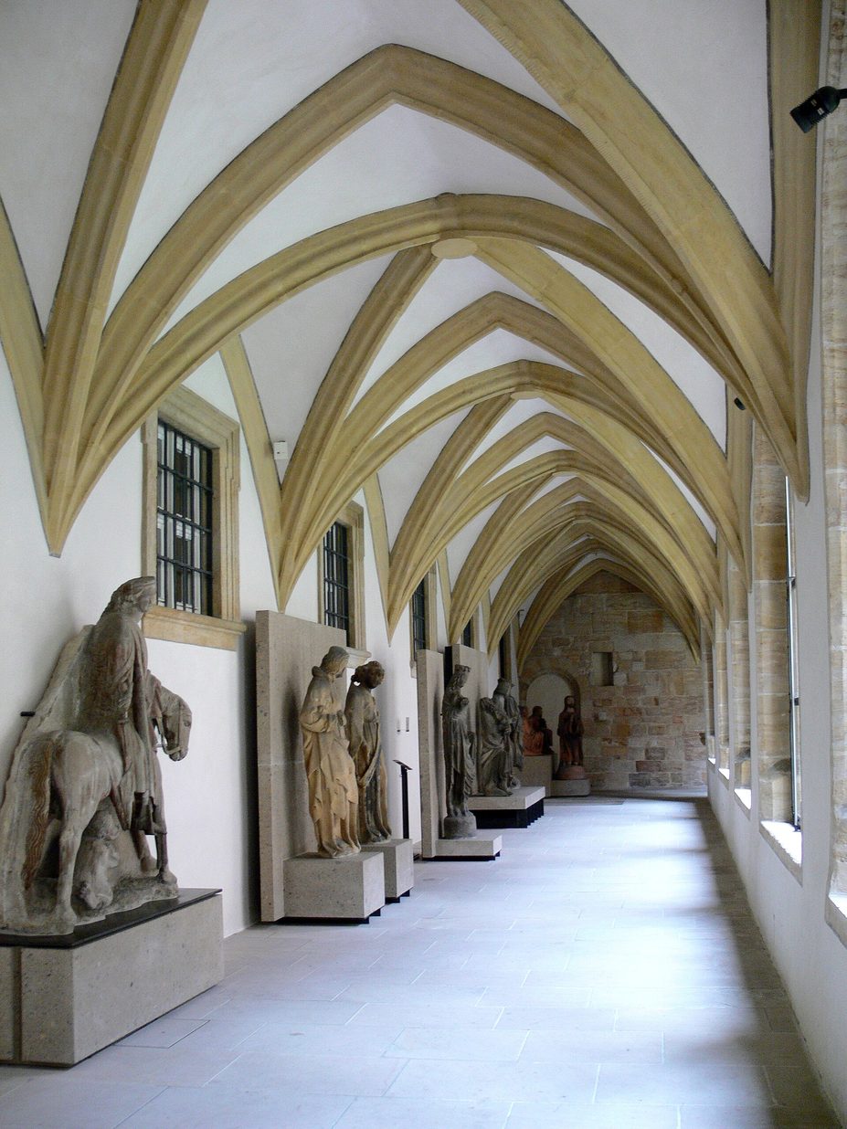 The Gothic cloister walk at Bamberg Cathedral with rib vaults and medieval stone sculptures displayed along it