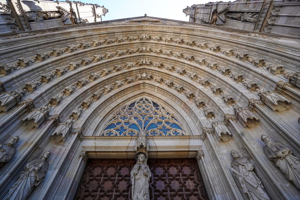 The carved central doorway of Barcelona Cathedral with rows of statues in its arches