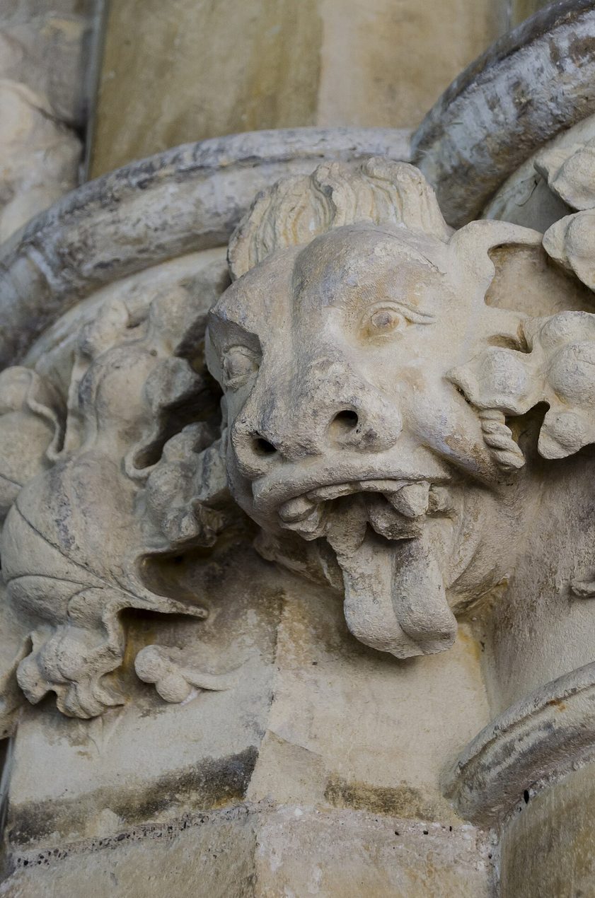 A carved stone grotesque of a beast's head among foliage at St Peter's, Barton-upon-Humber