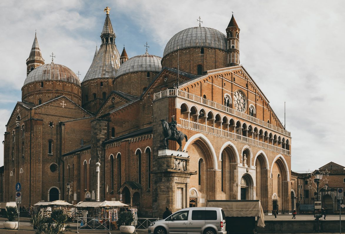 The brick facade of the Basilica of St Anthony in Padua, with its domes and slender towers rising behind