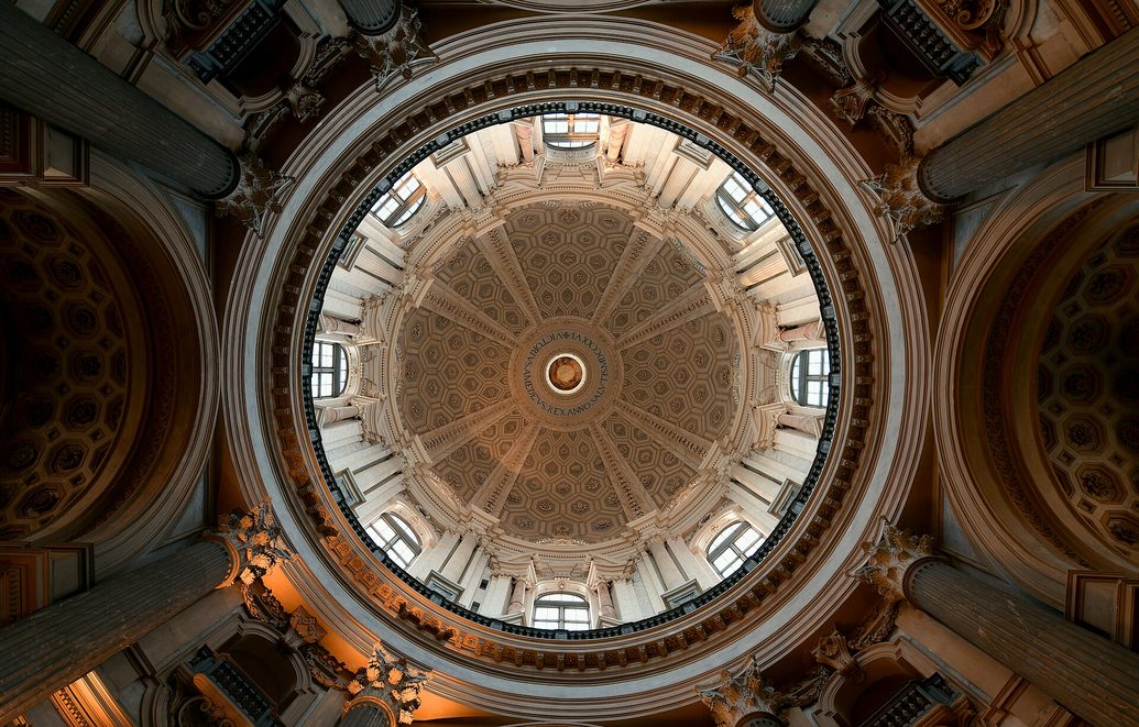 Looking up into the dome of the Basilica of Superga, a ring of windows and coffered decoration around the lantern