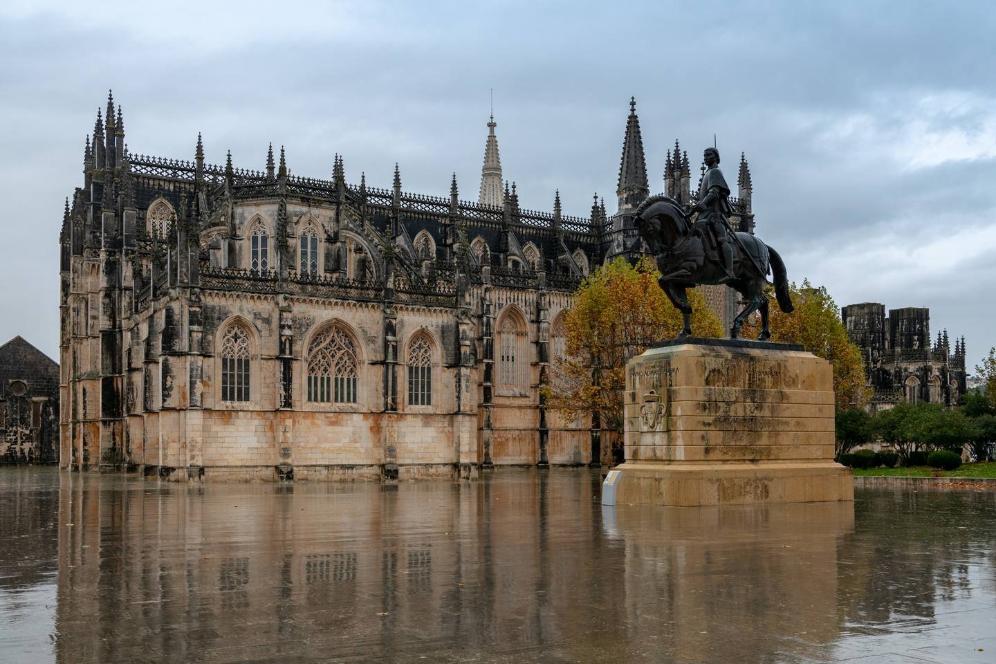 The flank of Batalha Monastery reflected in water