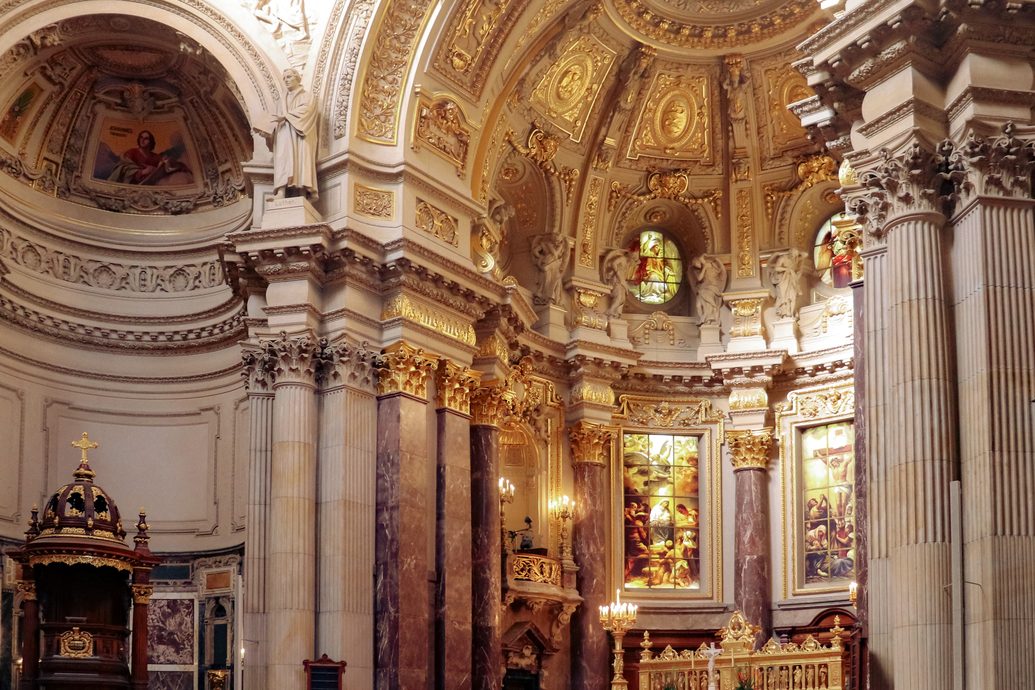 The interior of Berlin Cathedral, with marble columns, gilded decoration and the altar under the dome