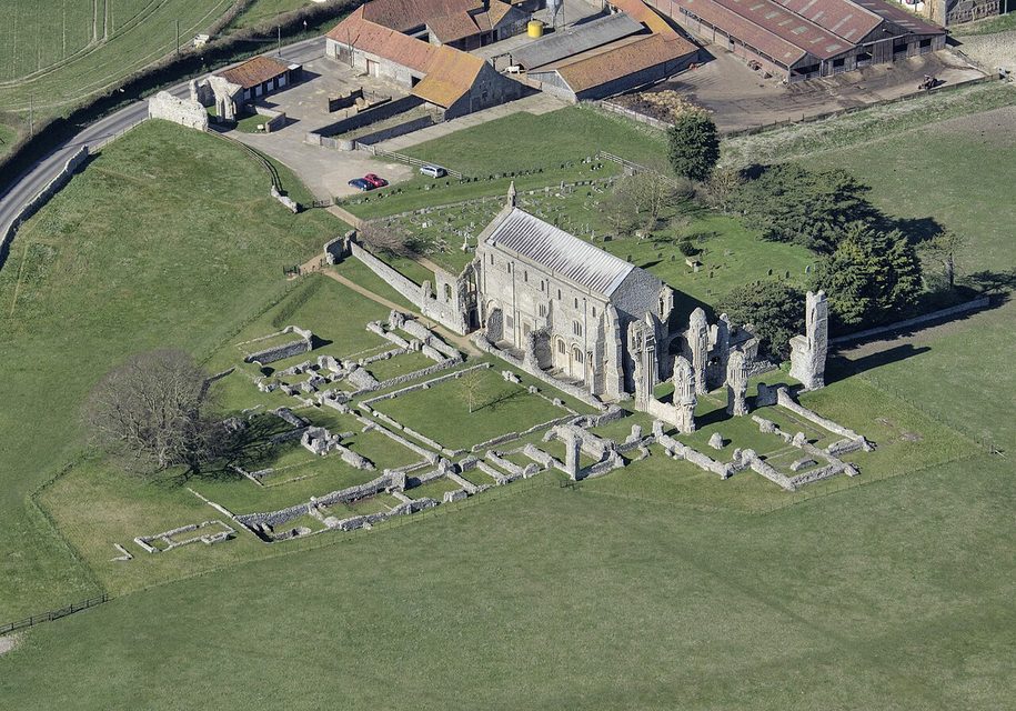An aerial view of Binham Priory, the church standing at the west end of the outlined ruins of the monastery among fields