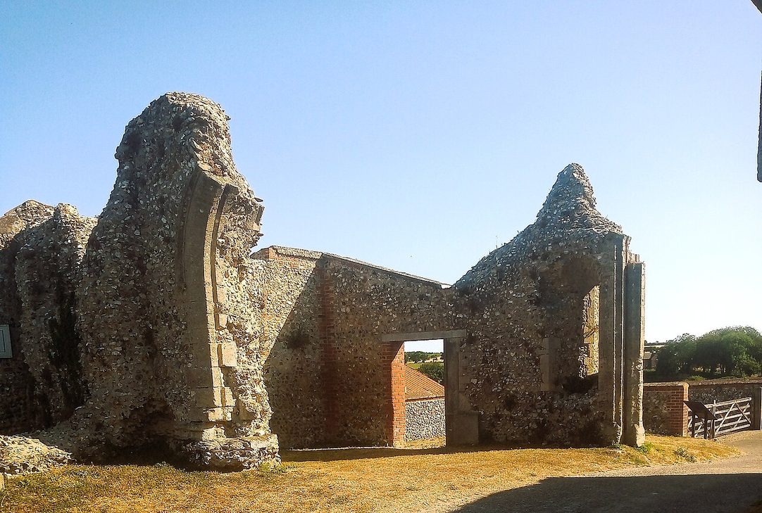 The ruined flint gatehouse of Binham Priory with a pointed archway