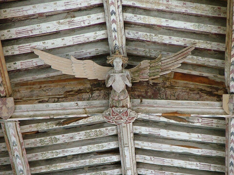 Close view of a carved wooden angel with spread wings on the roof of Blythburgh church