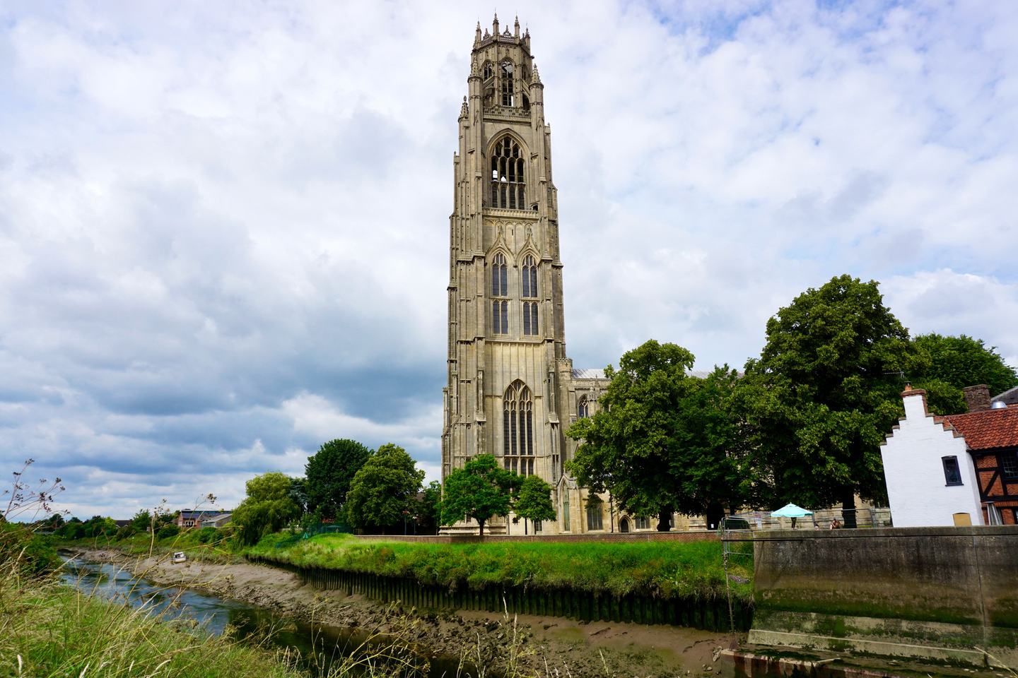 The tall tower of St Botolph's Church, the Boston Stump, rising beyond the River Witham and trees