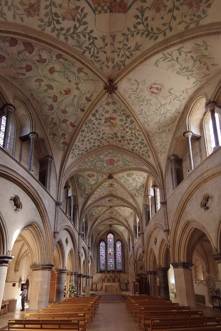 Inside Boxgrove Priory church, looking east through pointed arches under a painted vault