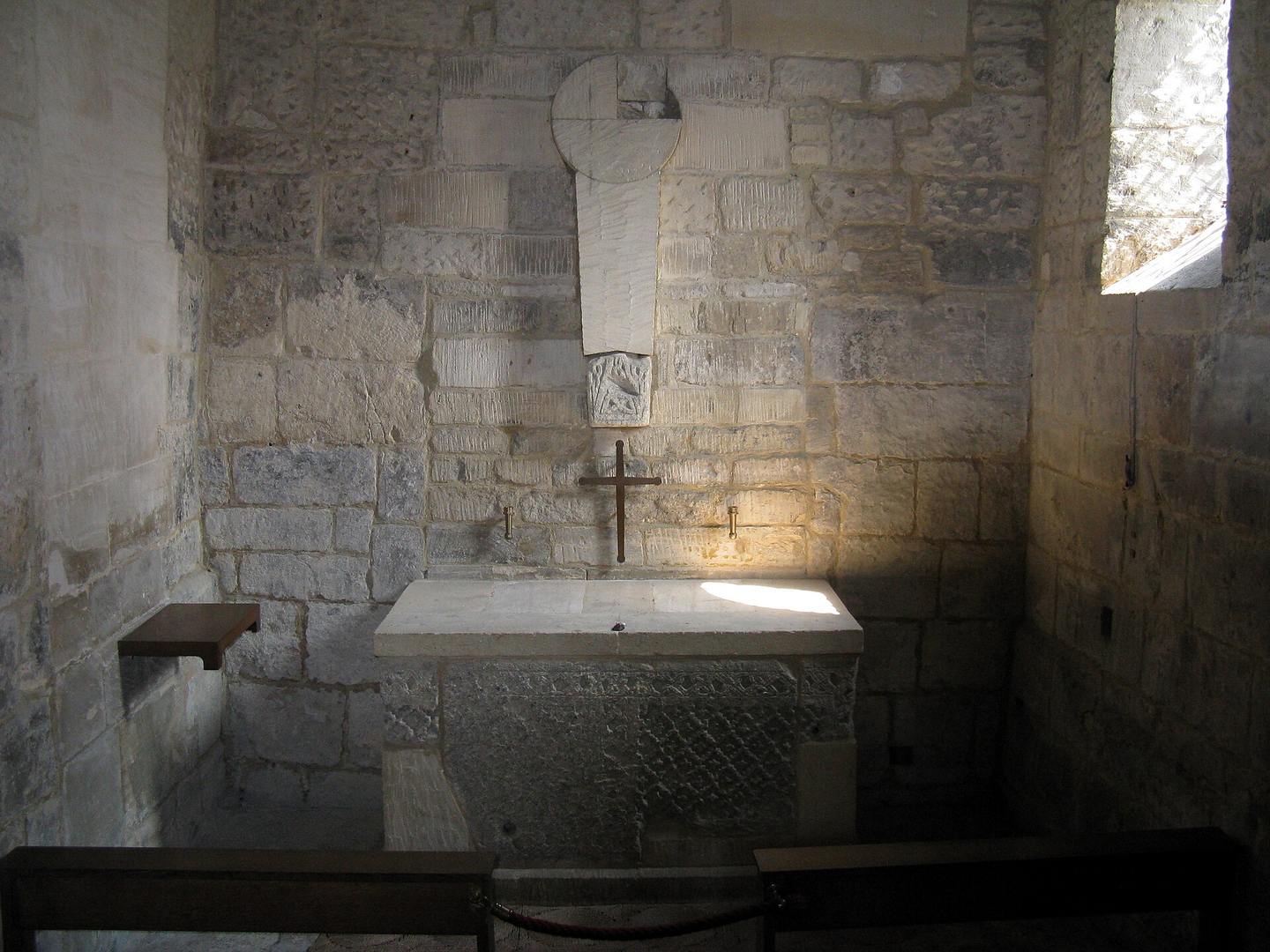 The small chancel of the Saxon church with a plain altar under a narrow window