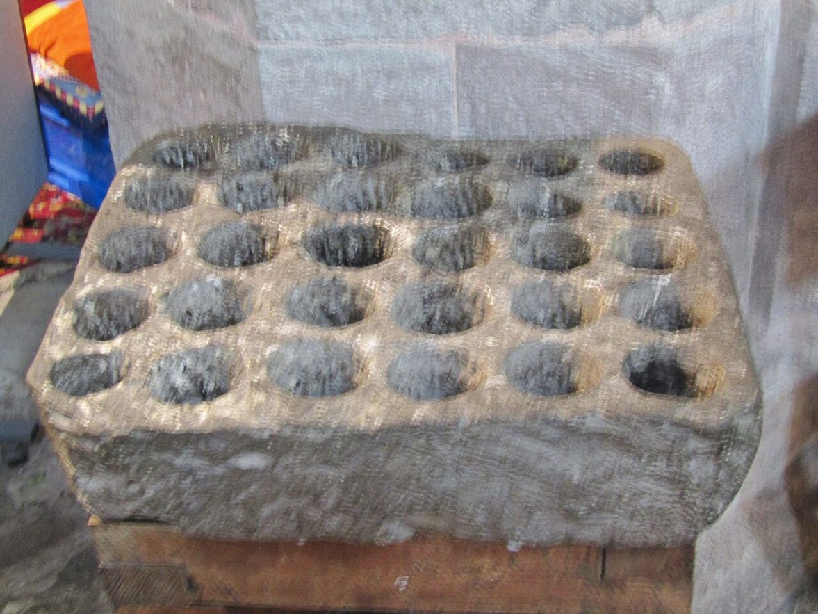 The cresset stone at Brecon Cathedral, a block of stone with thirty round cups cut into its top in rows