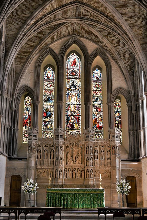 The tall Early English lancet windows at the east end of Brecon Cathedral above the high altar and stone reredos