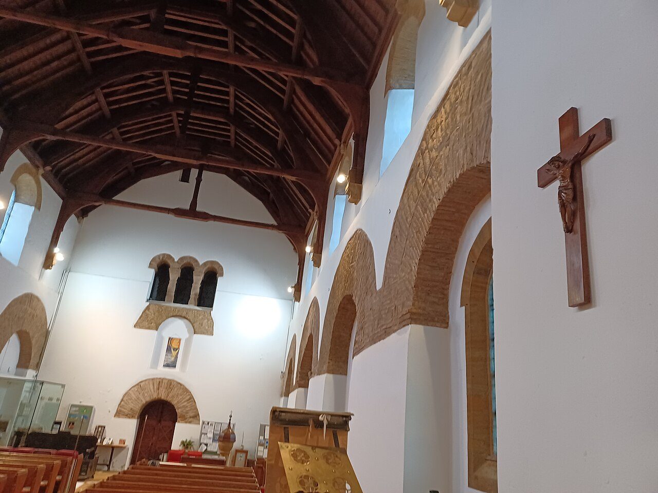 The nave of Brixworth church with its timber roof and the triple opening high in the west wall