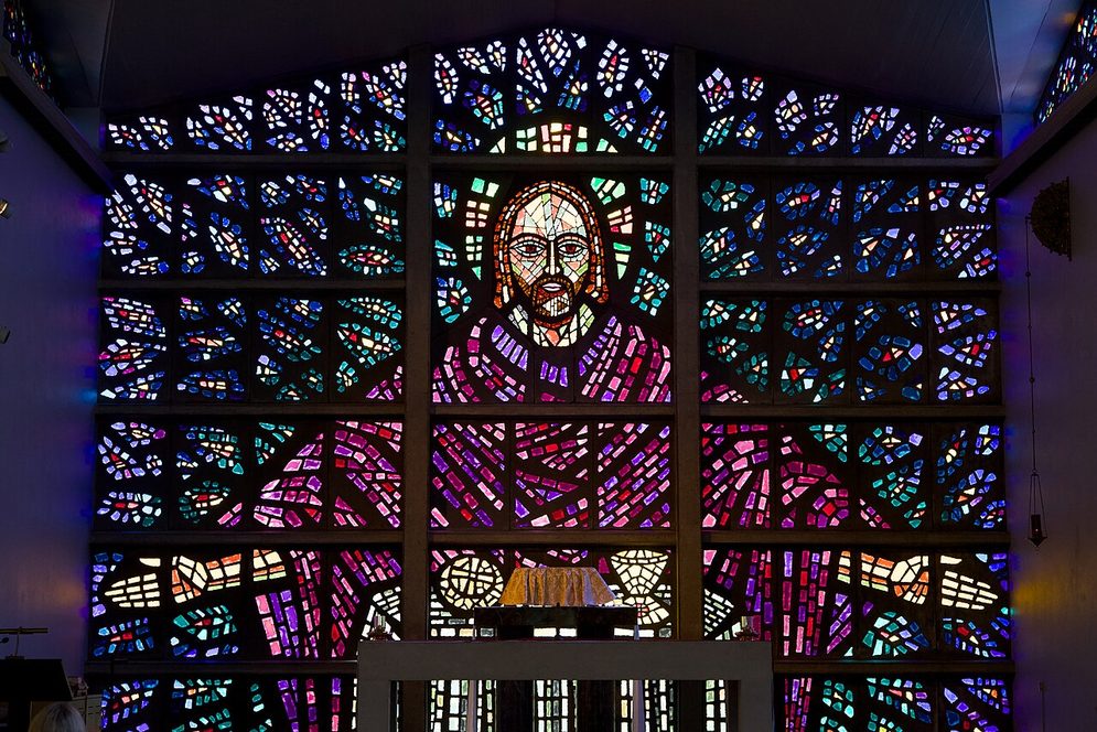 The Blessed Sacrament Chapel at Buckfast Abbey, lit by a wall of thick coloured glass showing Christ