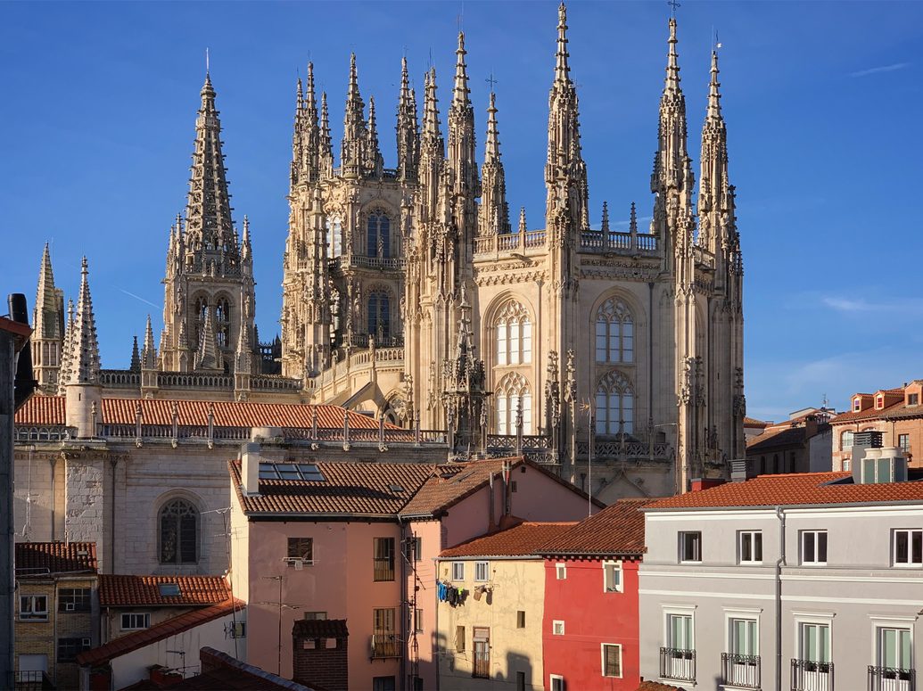 The twin openwork spires of Burgos Cathedral rising above the coloured houses of the old town
