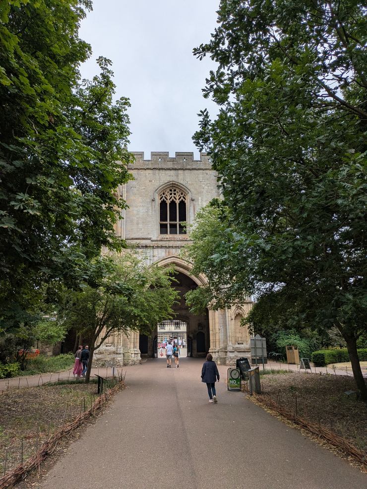 The medieval Abbey Gate in Bury St Edmunds seen down a tree-lined path