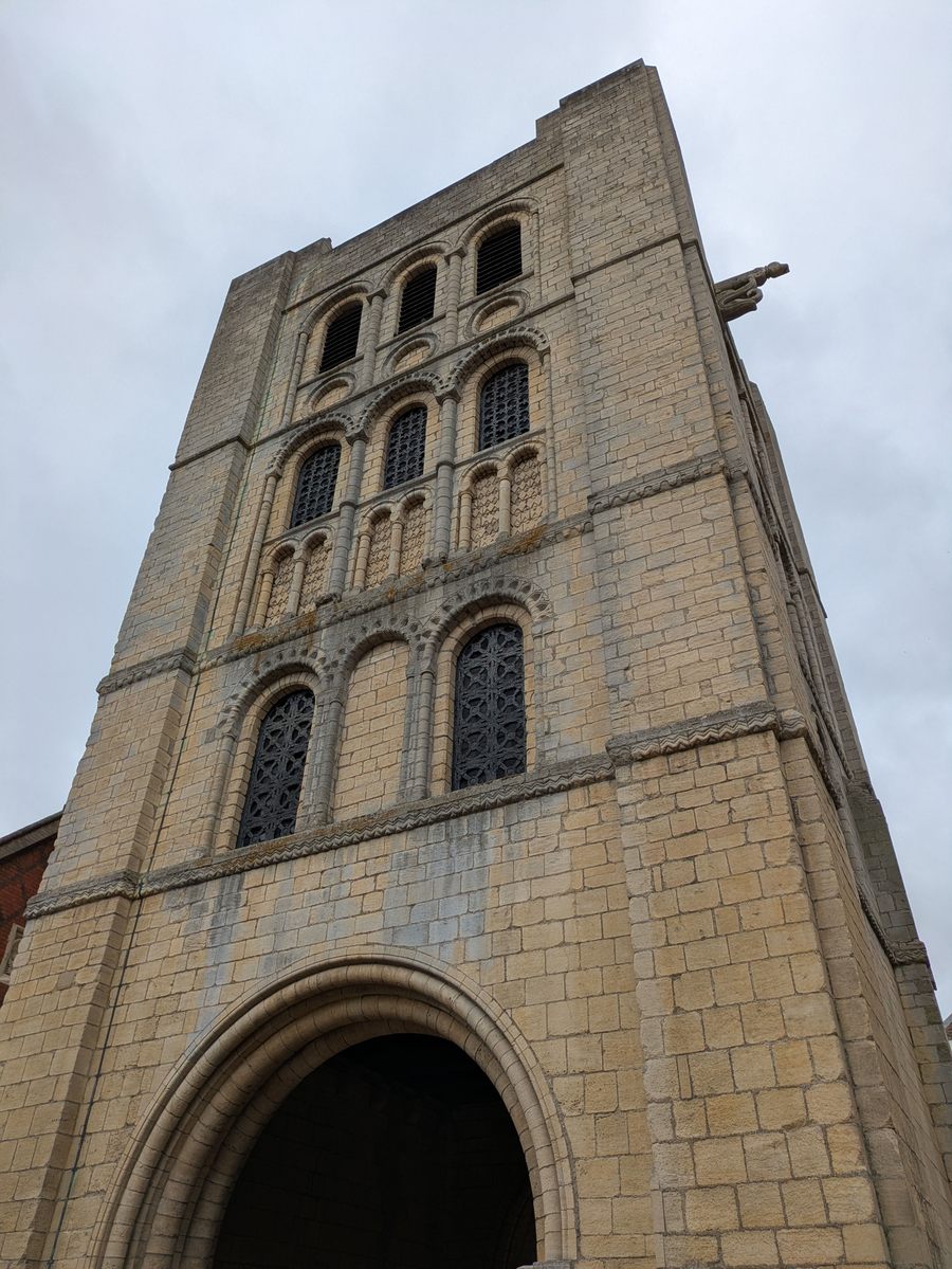 The Norman Tower in Bury St Edmunds, a tall square stone gate tower with round-arched windows