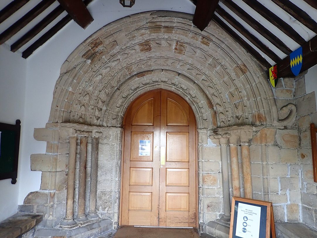 The round-arched late Norman south doorway of Cartmel Priory with its carved mouldings