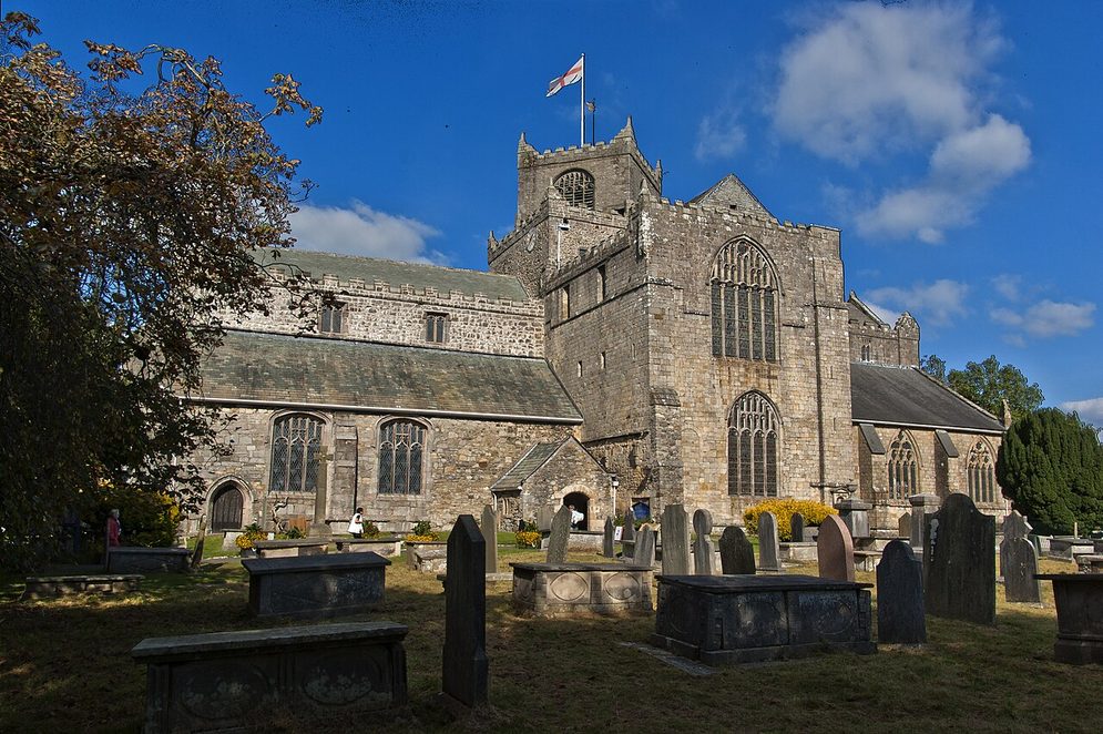 Cartmel Priory, Cumbria, seen across its churchyard, with the upper stage of the tower set diagonally on the lower