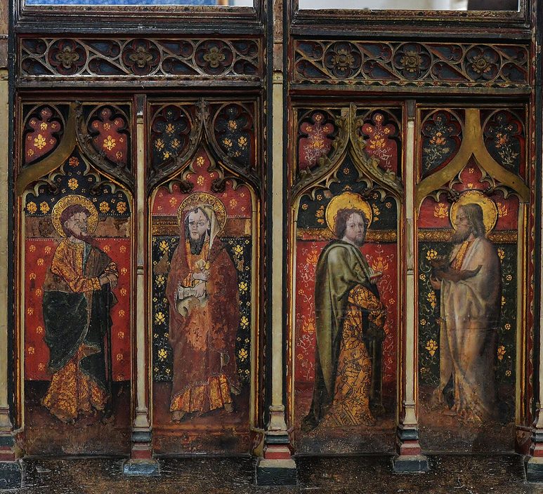 The painted rood screen at Cawston, with panels of saints in red and green robes below delicate tracery