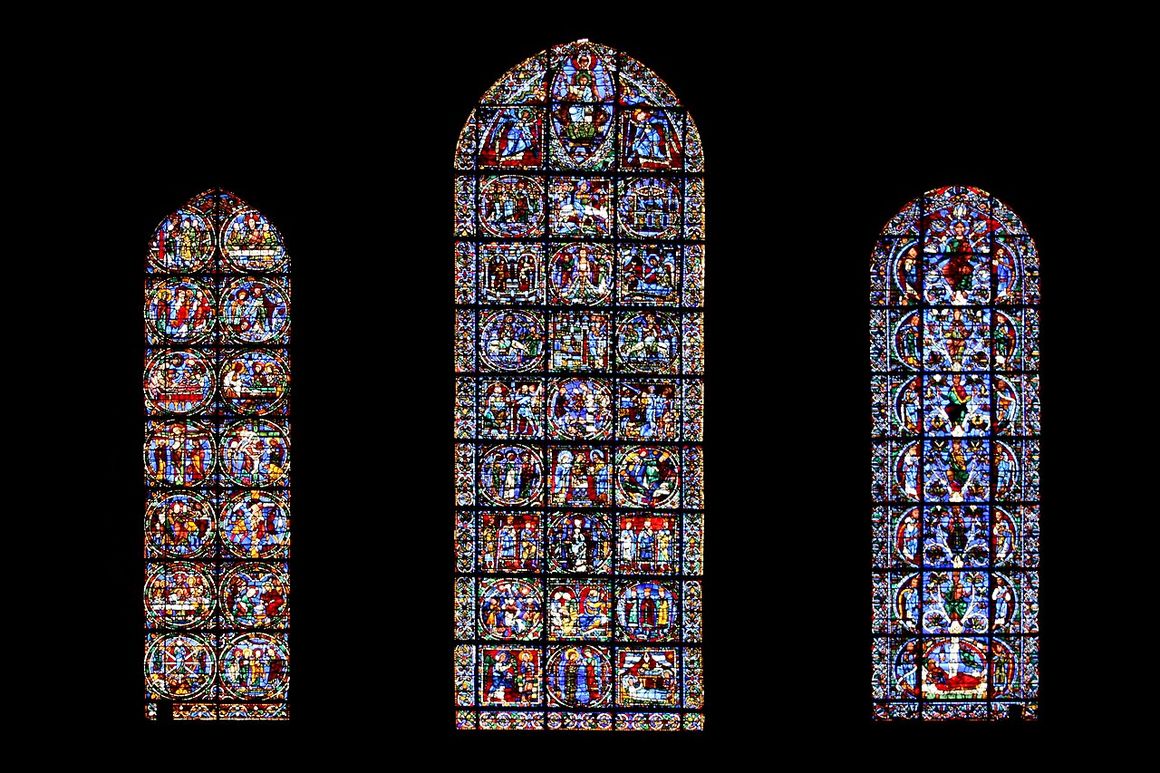 Three tall twelfth-century stained-glass lancet windows at the west end of Chartres Cathedral