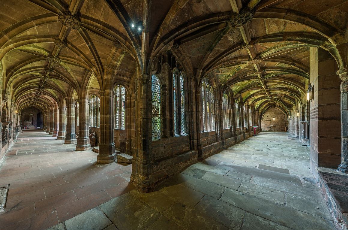 The vaulted cloister walk of Chester Cathedral with stained glass windows
