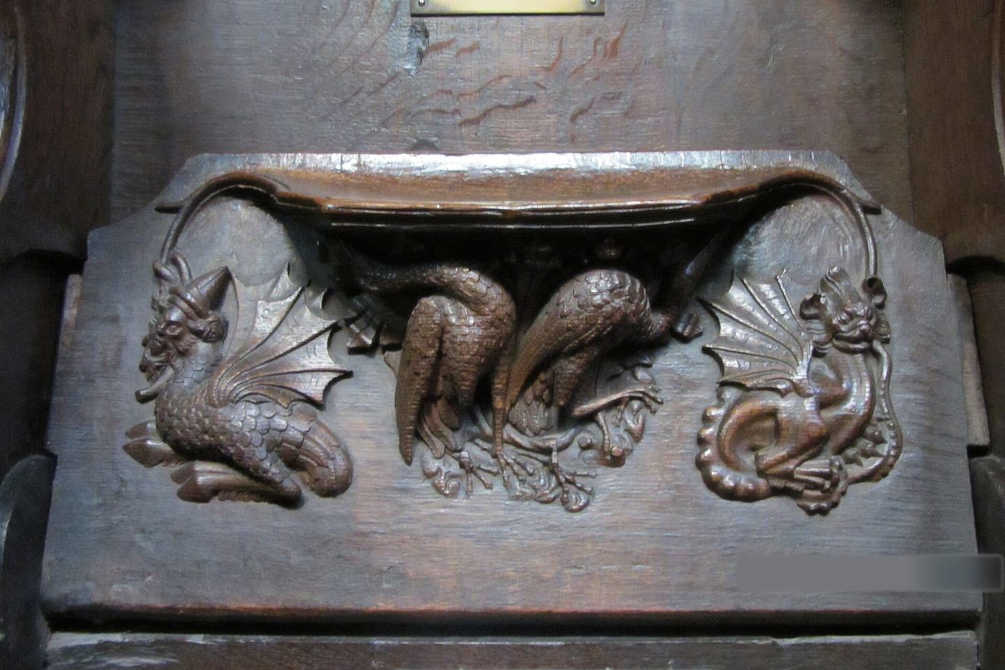 A carved medieval misericord under a quire seat at Chester Cathedral