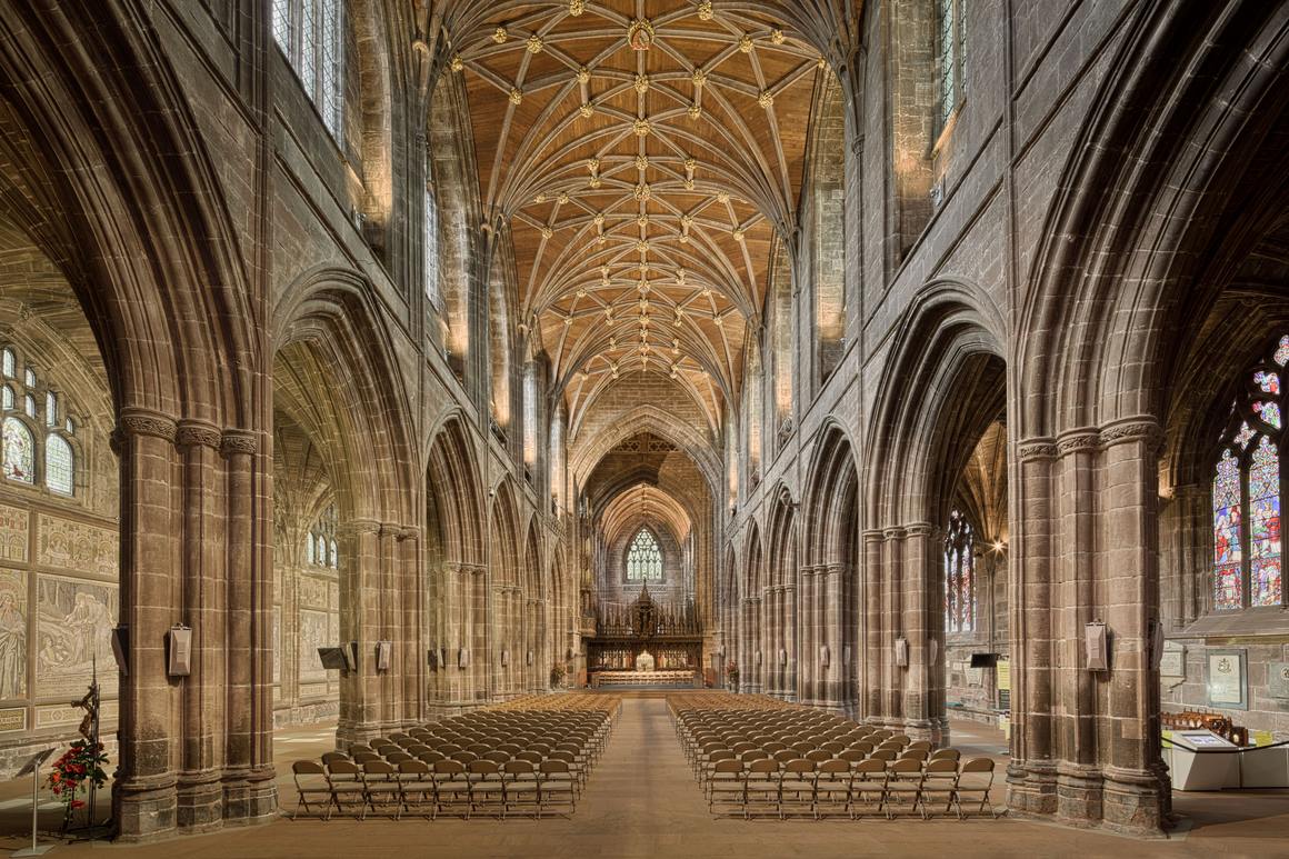 The nave of Chester Cathedral looking east, with red sandstone arcades and a vaulted roof