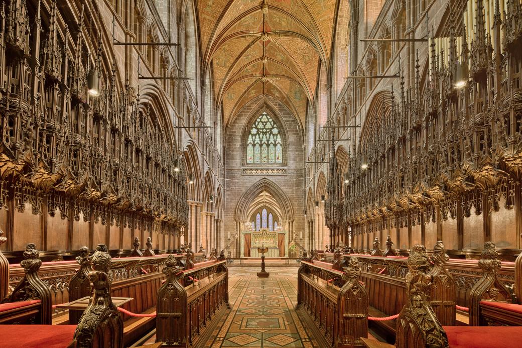 The quire of Chester Cathedral lined with tall carved oak stall canopies
