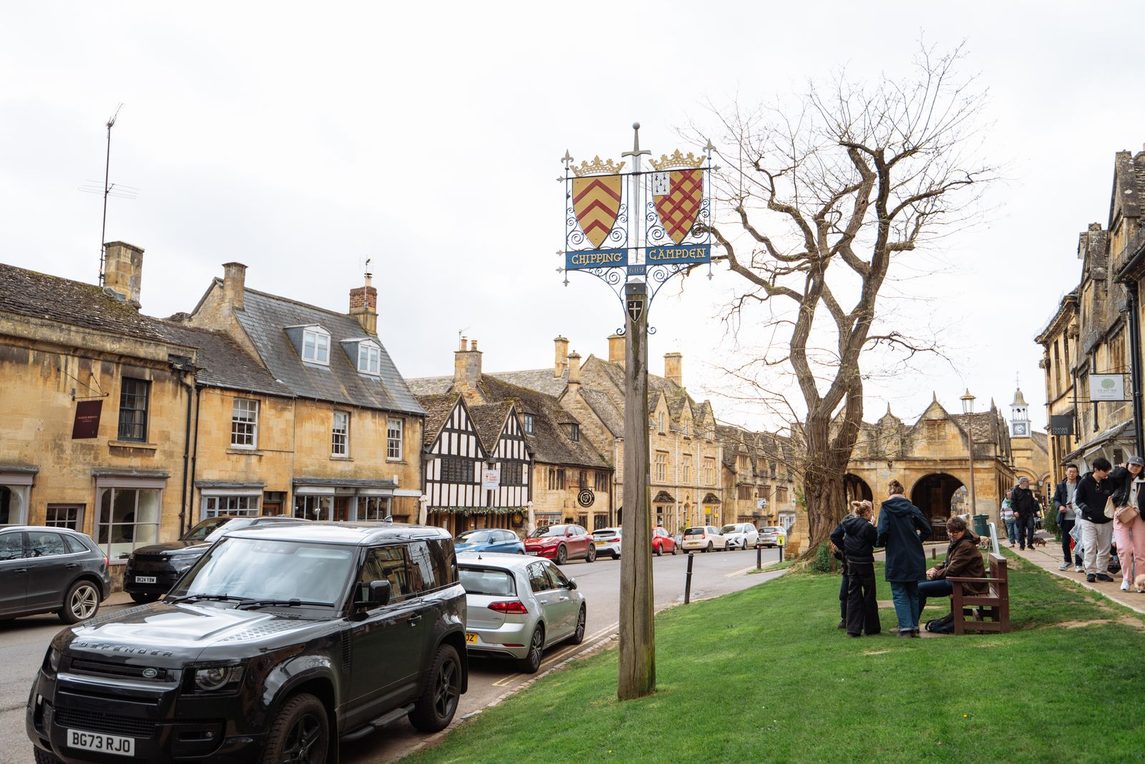 The High Street of Chipping Campden, lined with honey-coloured stone houses, with the Market Hall in the distance