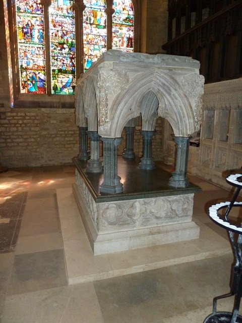 The reassembled stone shrine of St Frideswide in Christ Church Cathedral, Oxford, beneath a stained-glass window