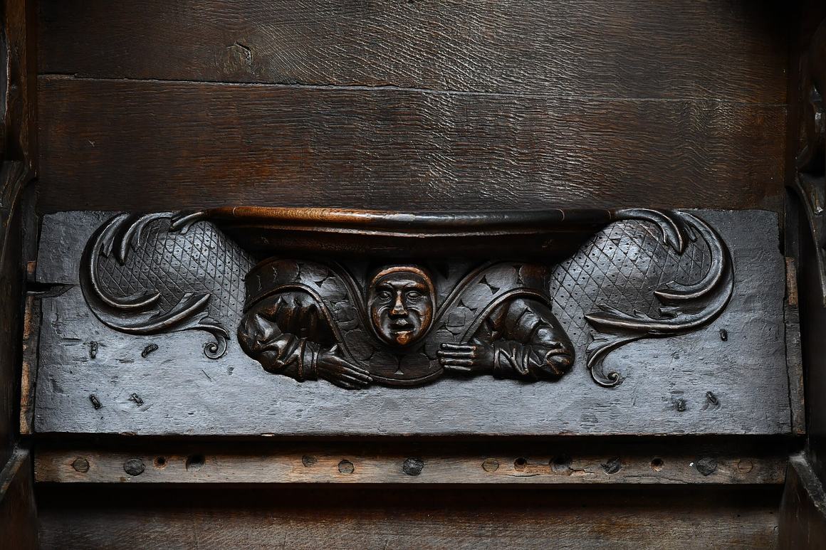 A carved medieval misericord under a choir seat at Christchurch Priory