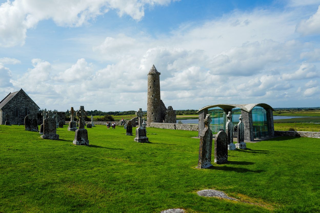 The ruined churches, high crosses and O'Rourke's round tower at Clonmacnoise, on a green slope above the River Shannon