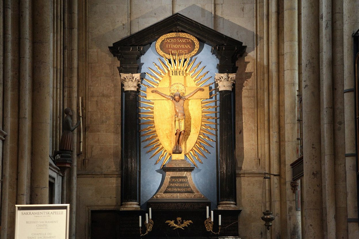 The Gero Cross in Cologne Cathedral, a carved wooden figure of Christ on a cross against a gilded Baroque sunburst