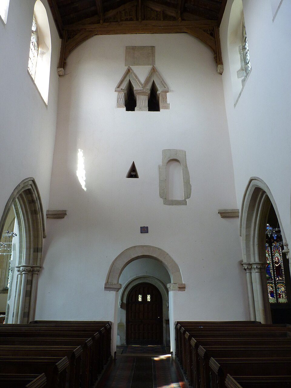 The tall white nave of St Mary's, Deerhurst, looking west, with a double triangular-headed window high in the west wall