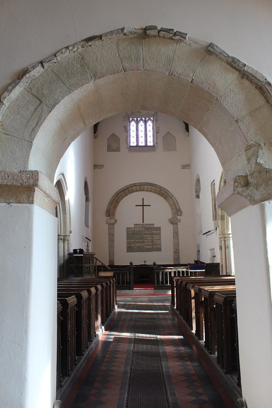 Looking from the west porch of Deerhurst church through a round arch into the nave