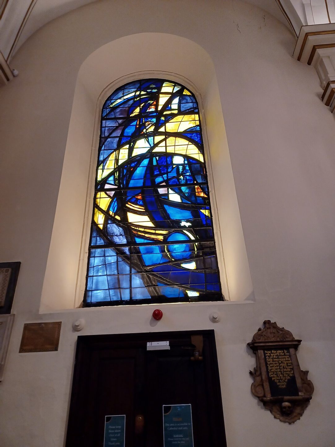 One of Ceri Richards's modern stained-glass windows in Derby Cathedral, swirling abstract shapes in deep blues above a doorway