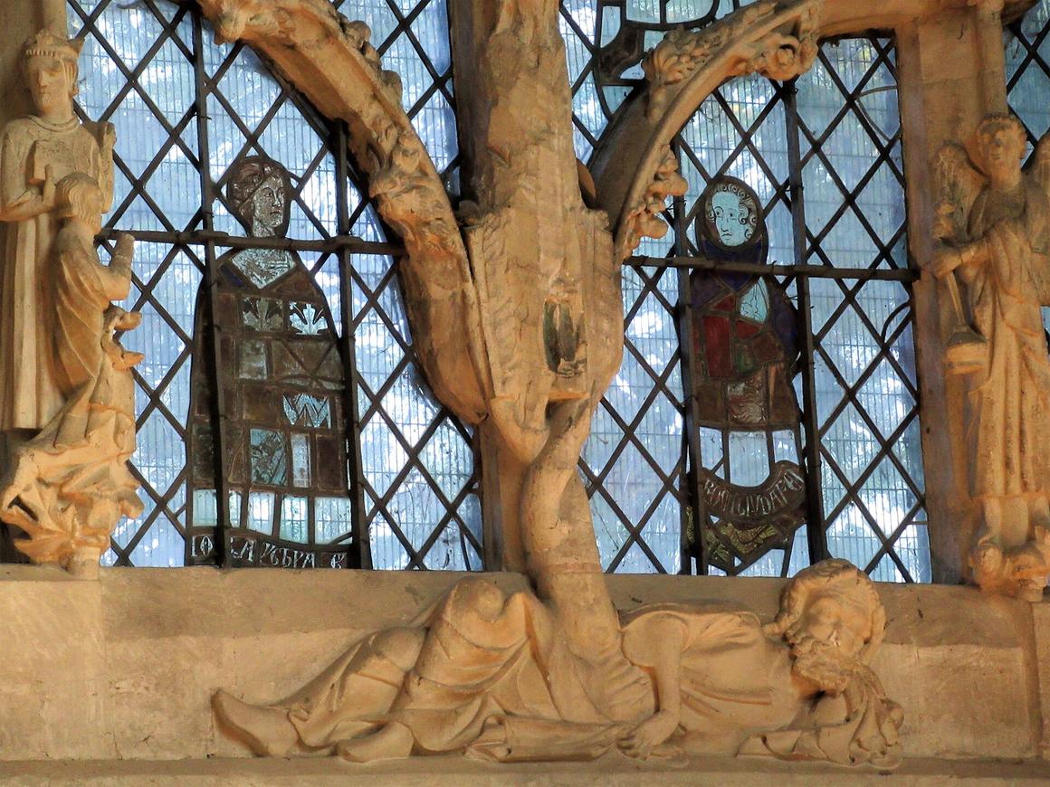 Close view of carved stone figures standing on the branches of the Jesse window tracery