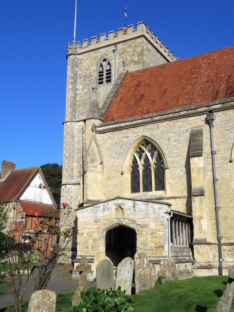 The square west tower of Dorchester Abbey with its red-tiled roofs beside it