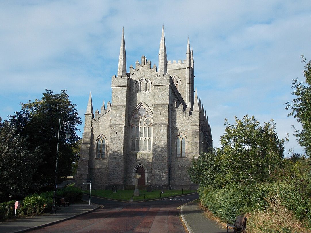 Down Cathedral, a grey stone Gothic church with a pinnacled tower, at the top of the road up the hill among trees