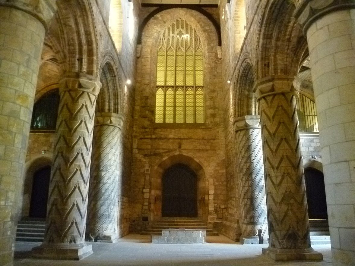 The Romanesque nave of Dunfermline Abbey, with massive round pillars carved with zigzag and spiral patterns