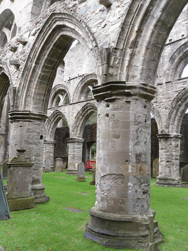 The roofless nave of Dunkeld Cathedral, its arcades of pointed arches standing on a lawn
