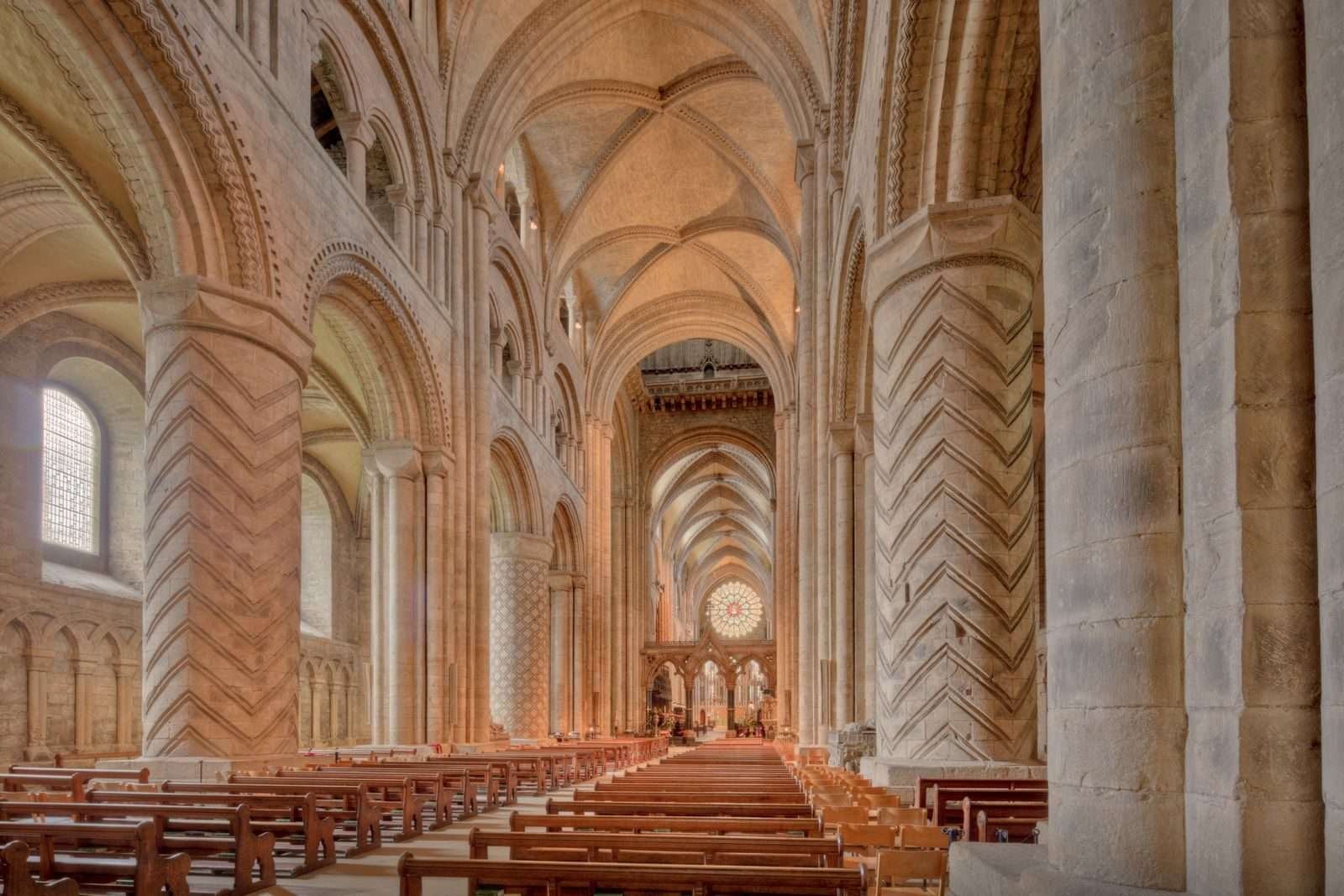 Durham Cathedral's Romanesque nave, incised stone piers beneath the pointed rib vault