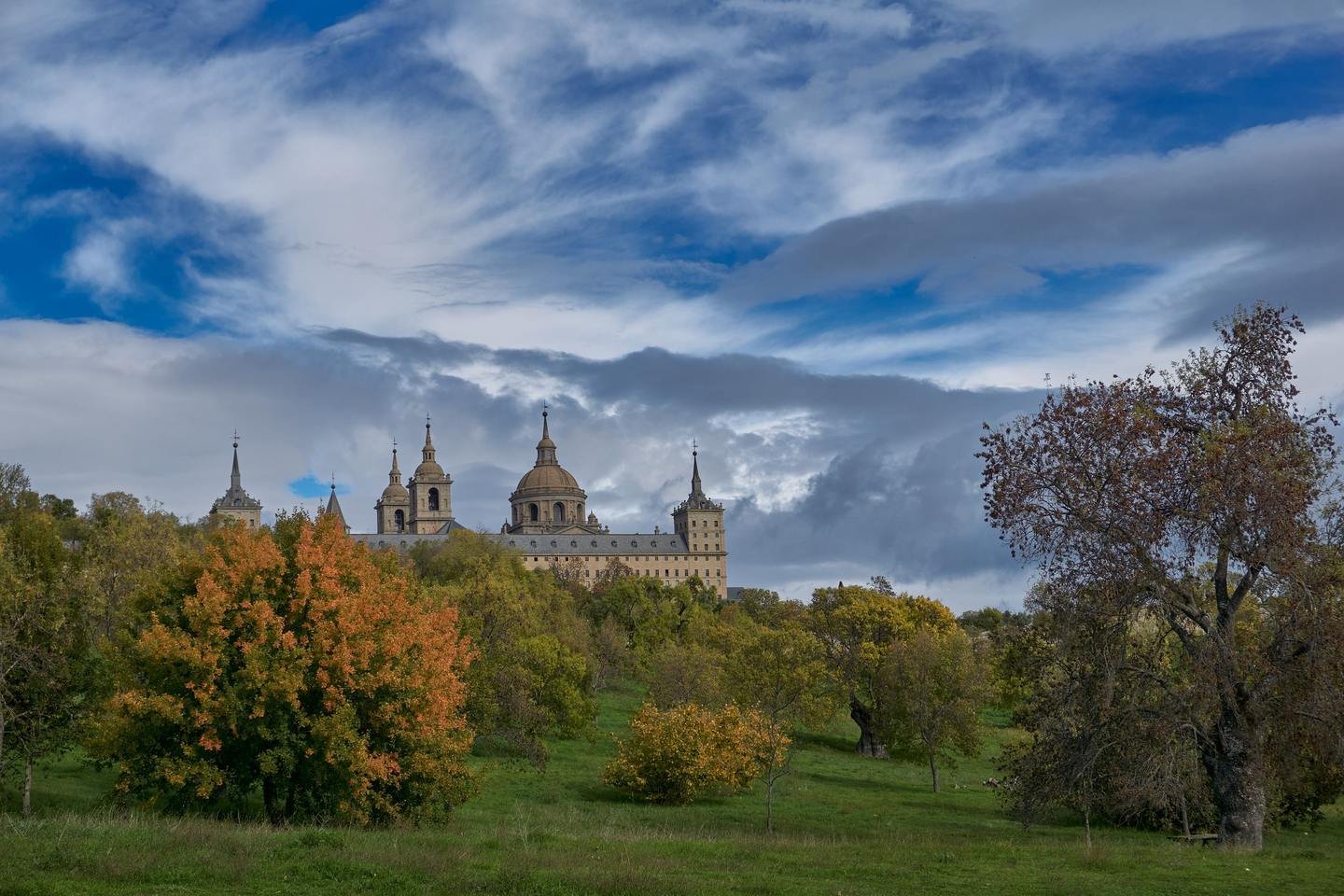 El Escorial monastery rising above autumn trees