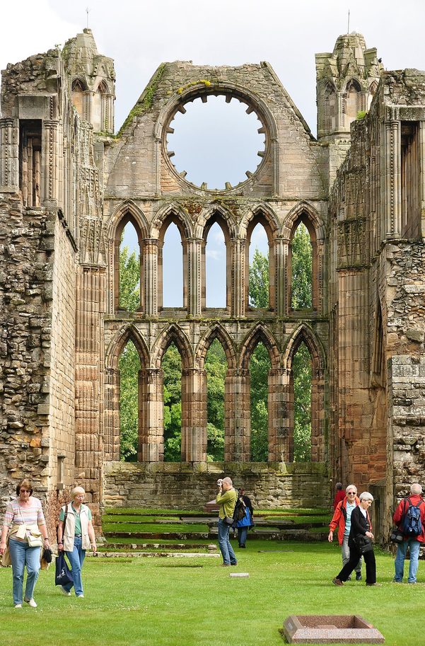 The east end of Elgin Cathedral, with two tiers of tall lancet windows below a round rose window